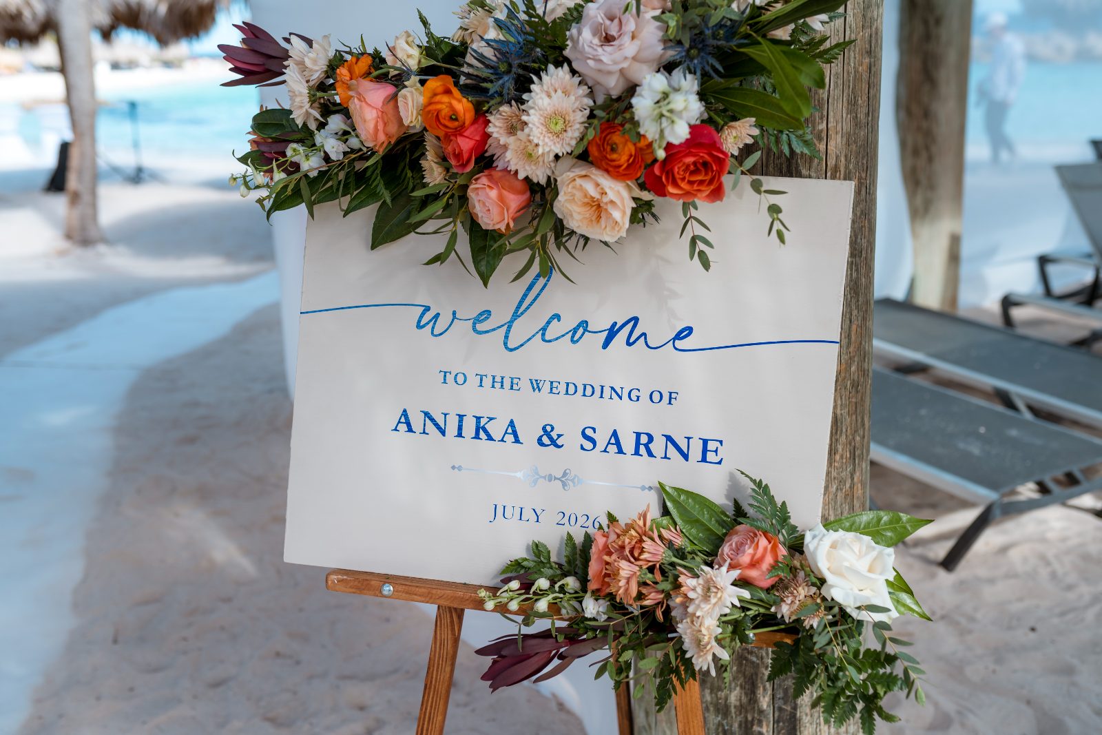 The sign at Avila Beach Hotel welcomes guests to the wedding of Anika and Sarne in July 2023, adorned with floral decorations