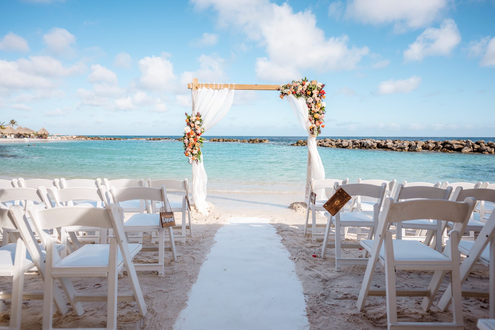 Anika and Sarne are getting married at Avila Beach Hotel, with a floral arch overlooking the ocean and rows of white chairs set up on the sand
