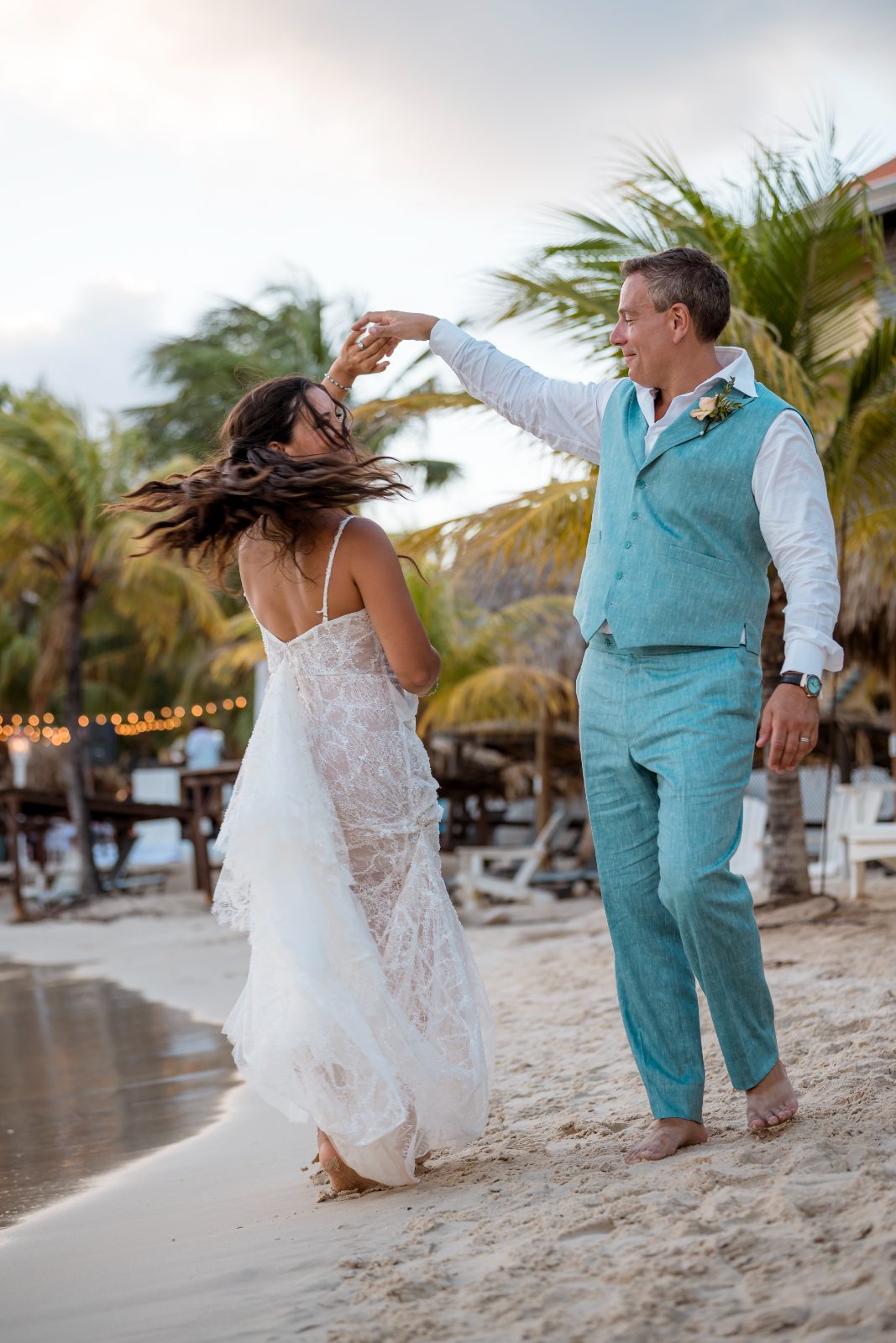 Anika and Sarne dance on the beach at the Avila Beach Hotel, surrounded by palm trees and the ocean
