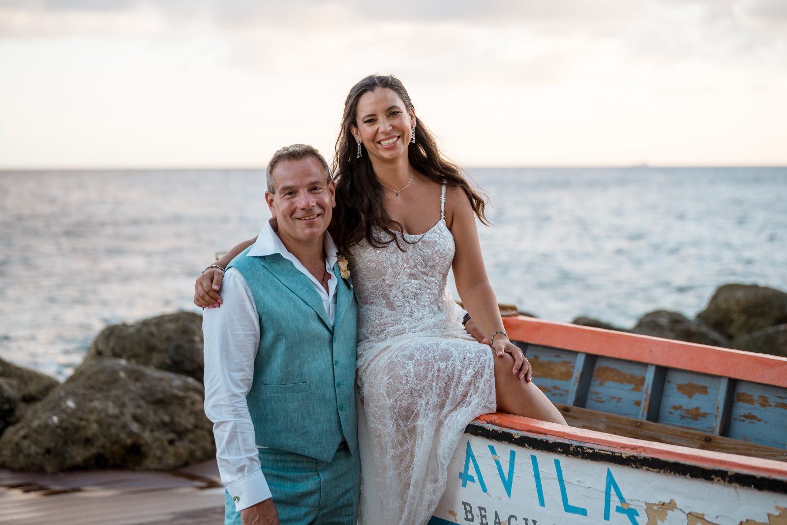 Anika and Sarne pose together on a boat at Avila Beach Hotel, with the ocean and rocks visible in the background