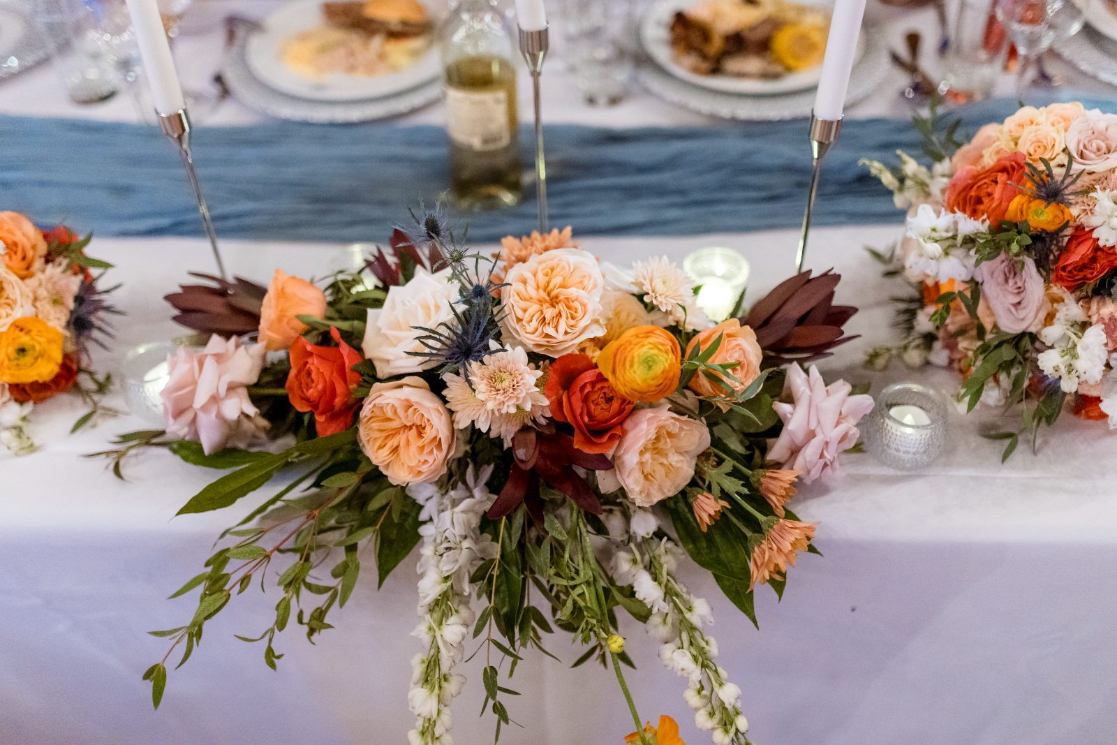 Anika and Sarne are celebrating their wedding at Avila Beach Hotel, with a decorated table featuring floral arrangements and lit candles