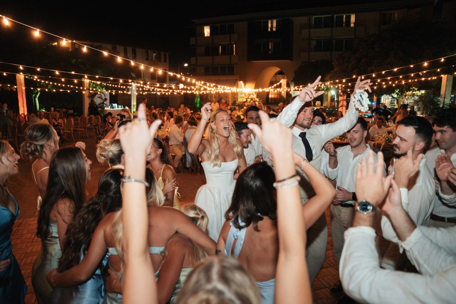 Cailey and Noel celebrate their wedding at Avila Beach Hotel in Curaçao, surrounded by guests dancing under string lights at night