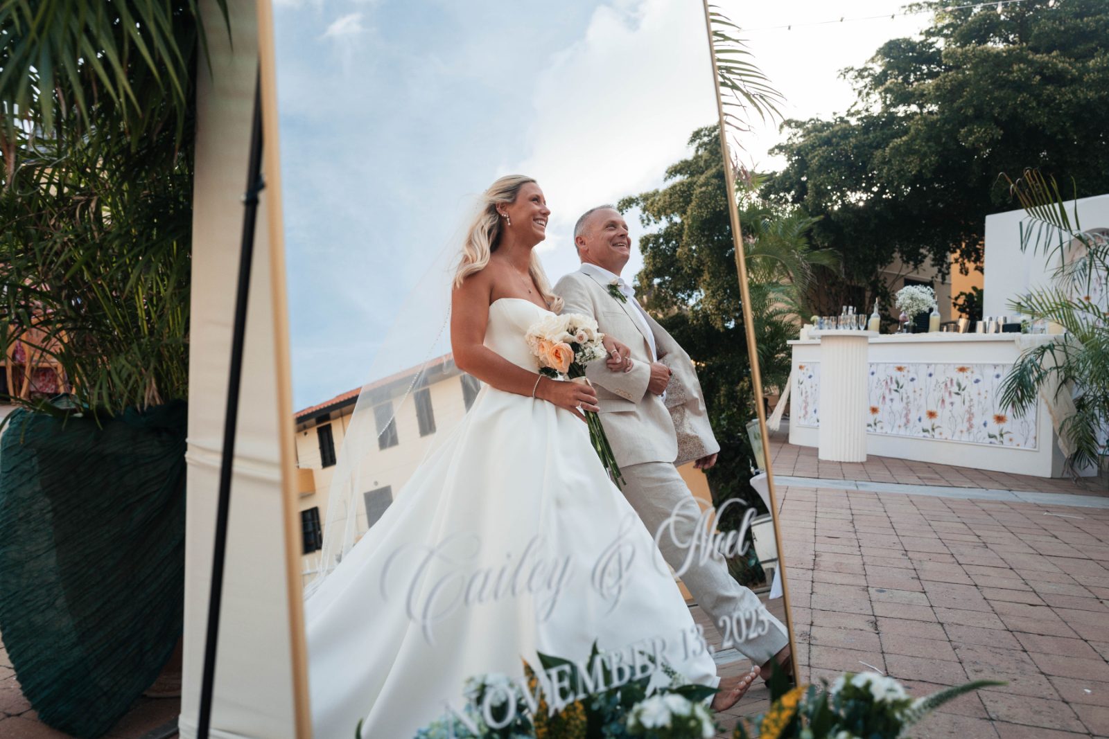 Cailey and Noel are walking together at their wedding at Avila Beach Hotel in Curaçao, reflected in a large mirror