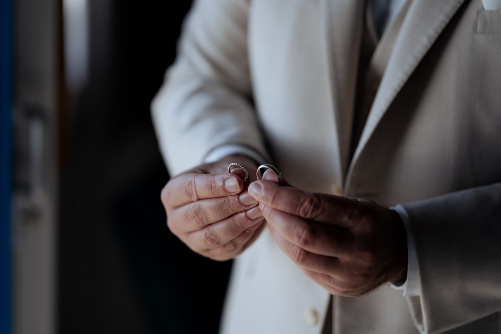 Derek holds two wedding rings in his hands at Avila Beach Hotel in Curaçao
