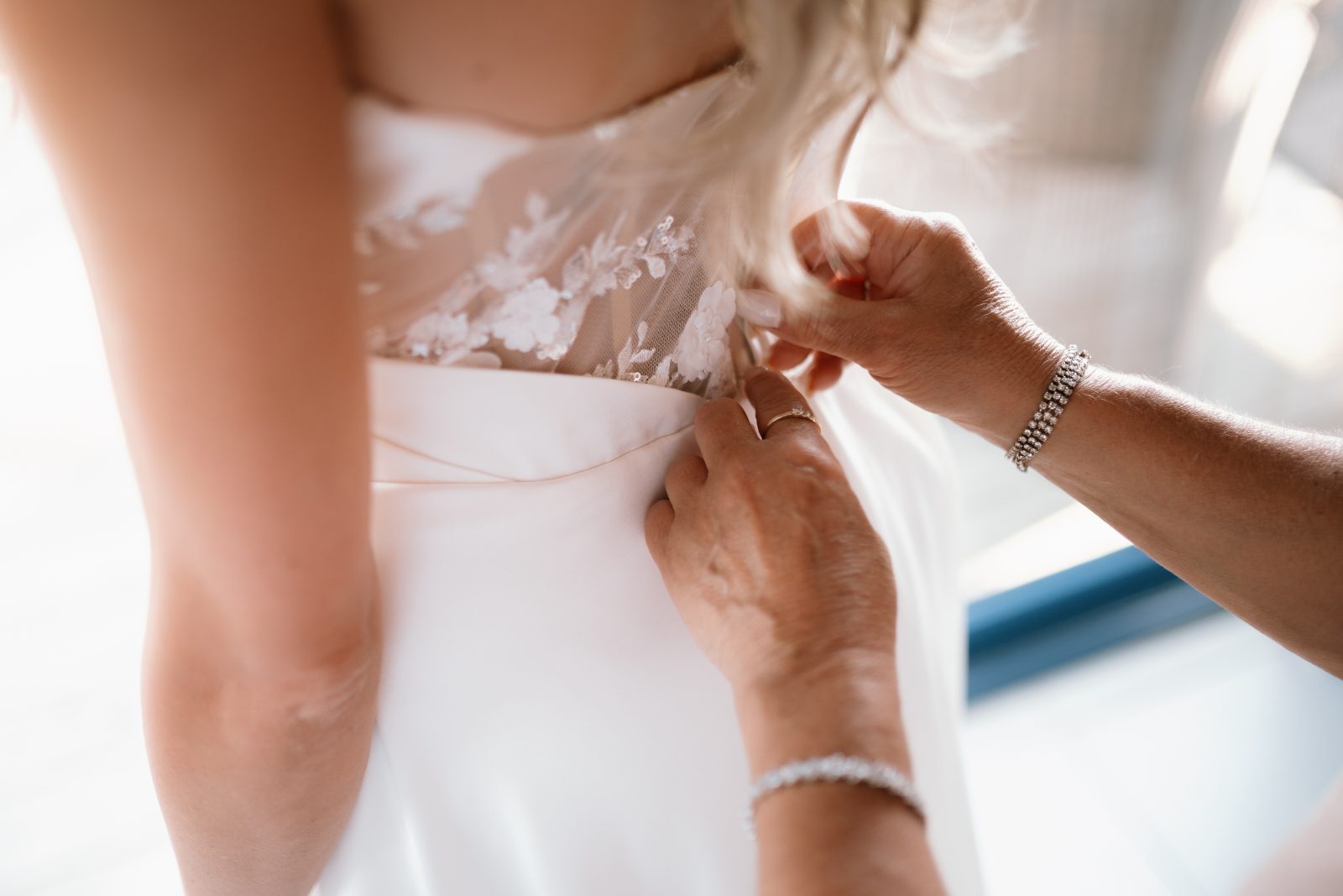 Erica’s dress is being fastened by another person at Avila Beach Hotel in Curaçao just before the wedding ceremony