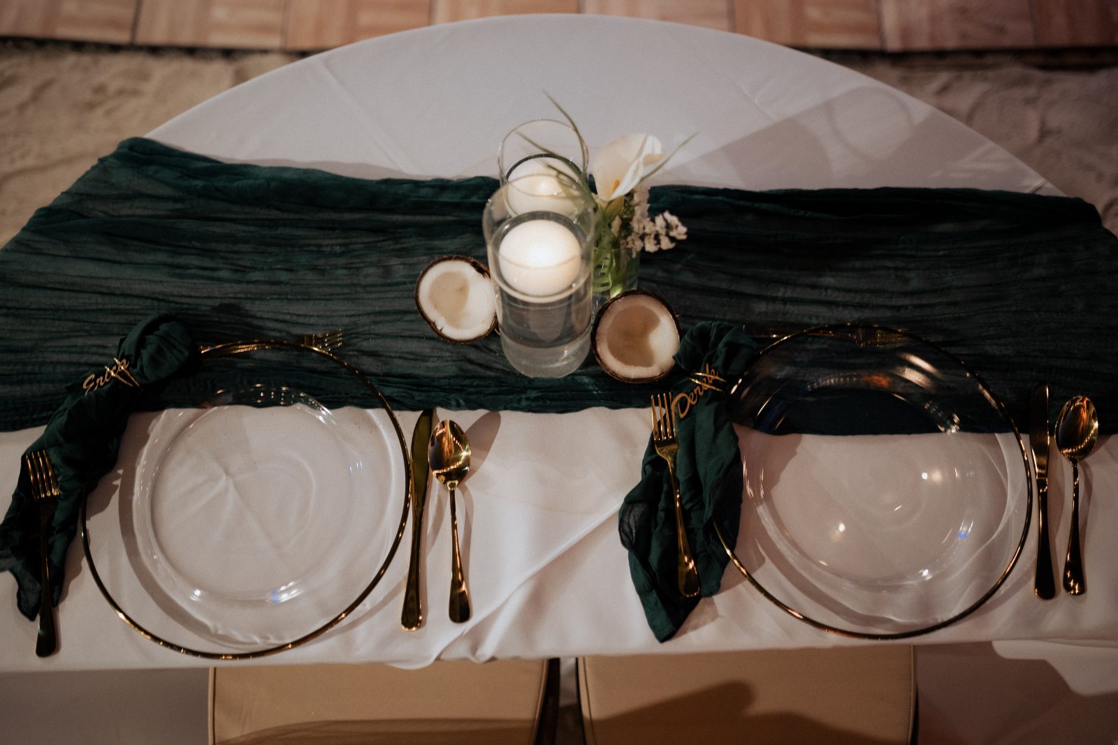 The wedding setting at Avila Beach Hotel, Curaçao features a decorated table with two place settings, each with a glass plate and gold utensils