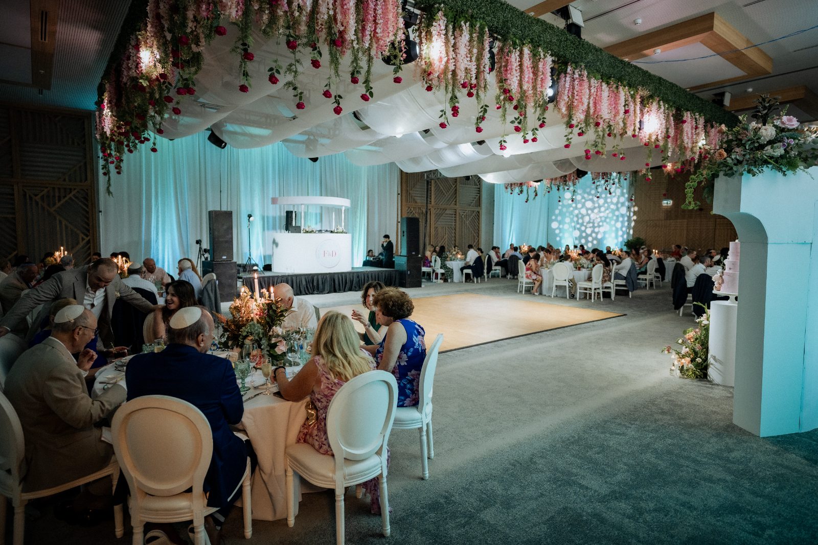 Frannie and Dustin celebrate their wedding reception at the Curaçao Marriott Beach Resort, surrounded by guests seated at tables with floral decorations