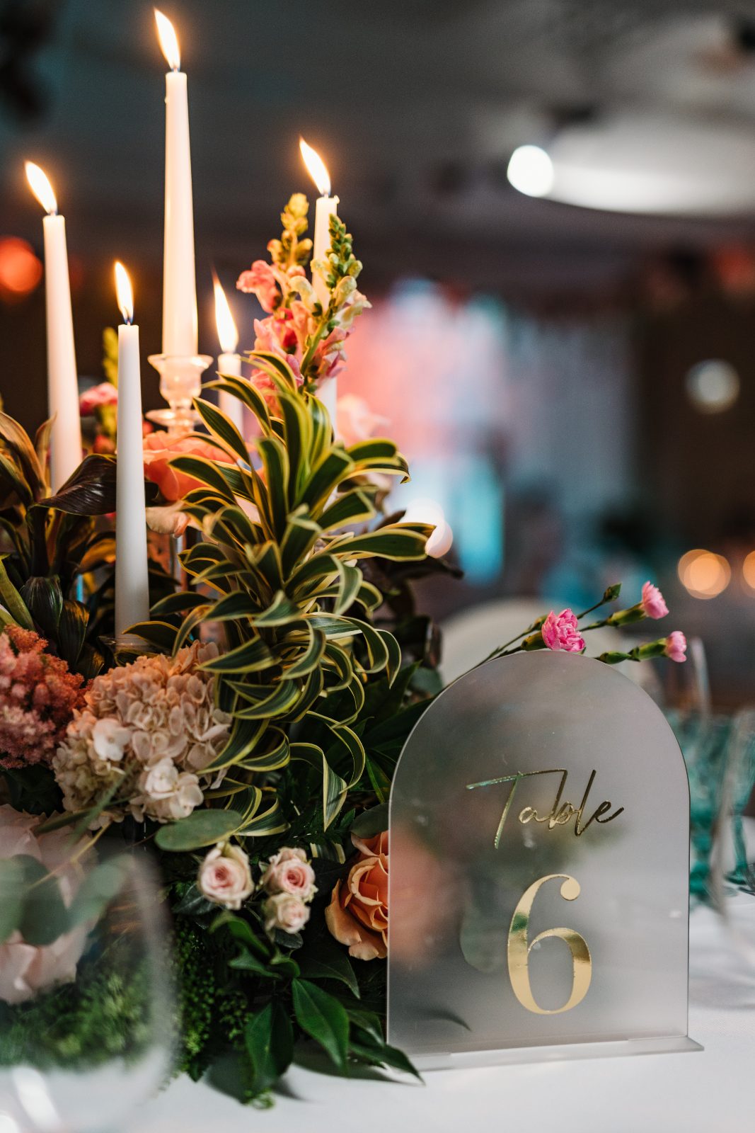 Frannie and Dustin's wedding at the Curaçao Marriott Beach Resort features a table centerpiece with candles and fresh flowers, labeled as Table 6