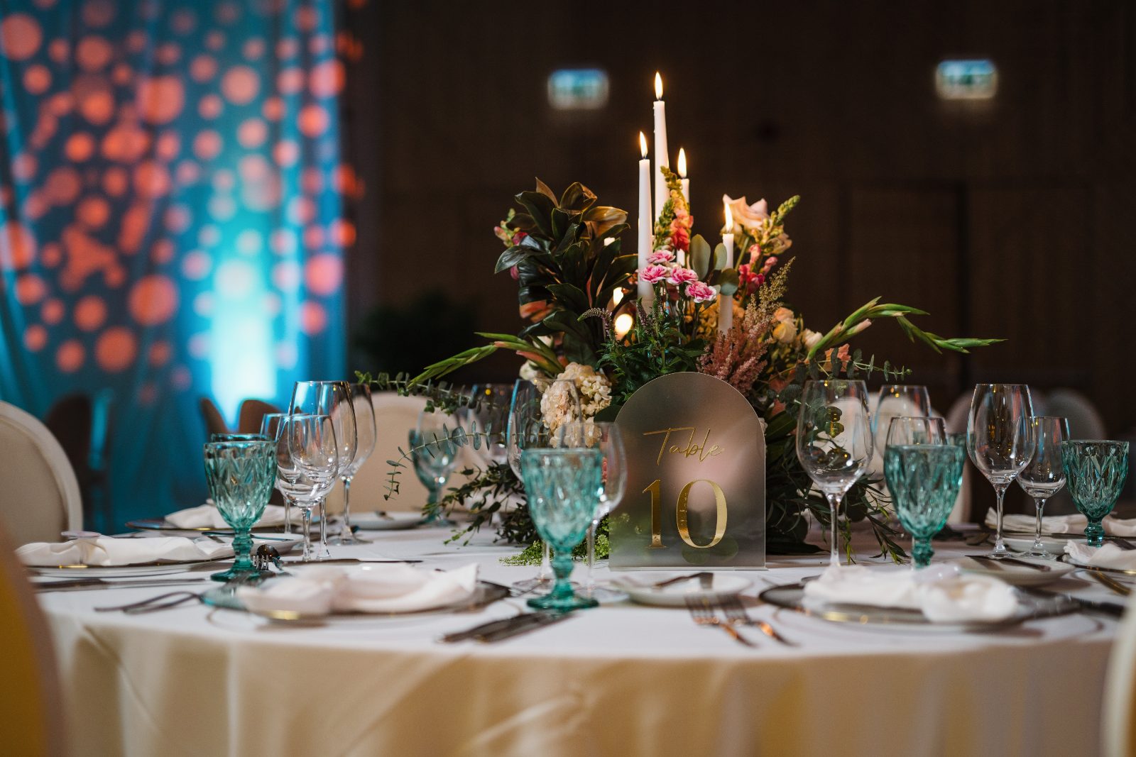Frannie and Dustin's wedding reception at Curaçao Marriott Beach Resort features a decorated table with candles, flowers, and table number ten