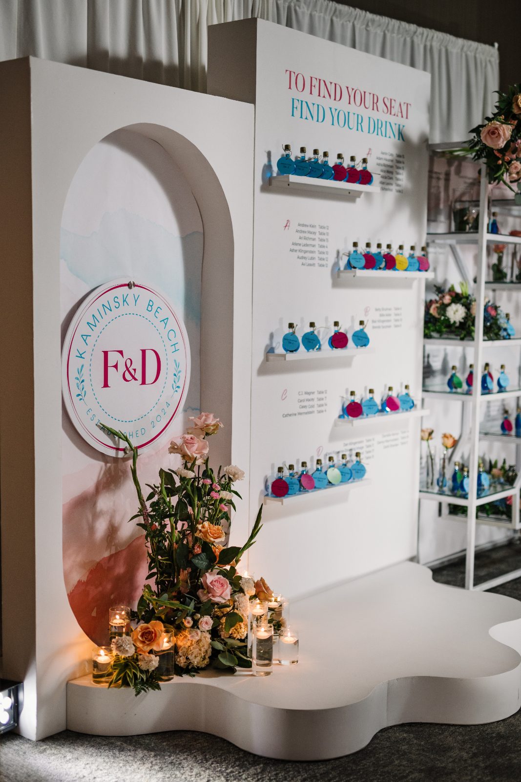 Frannie and Dustin's wedding display at the Curaçao Marriott Beach Resort features a seating chart and Mini Blue Curacao wedding favors with vibrant decor and floral arrangements