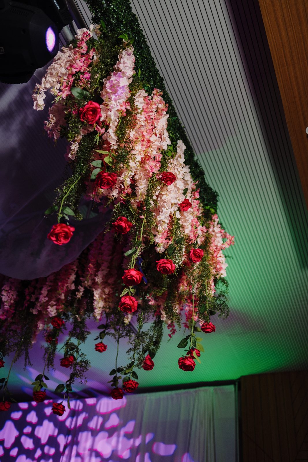 Frannie and Dustin's wedding at the Curaçao Marriott Beach Resort features a floral arrangement of pink and red flowers hanging from the ceiling
