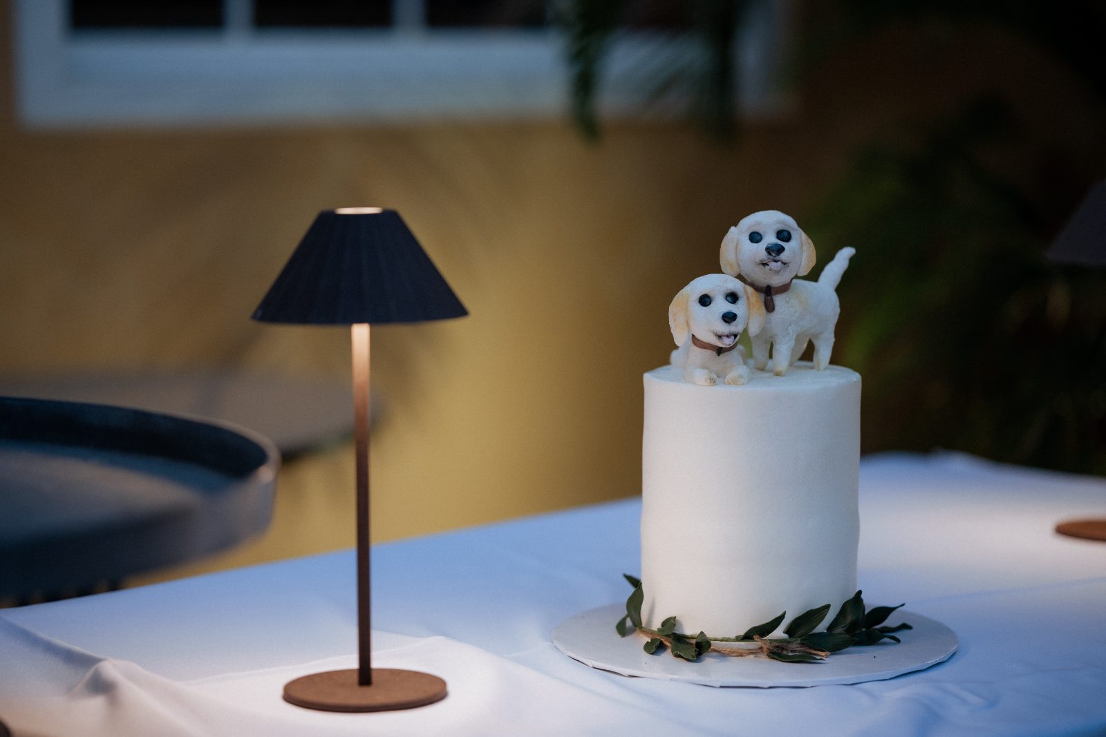 Frannie and Dustin's groom's cake at the Grand Café ‘Gouverneur de Rouville’ features two dog figurines on top, surrounded by a simple decoration