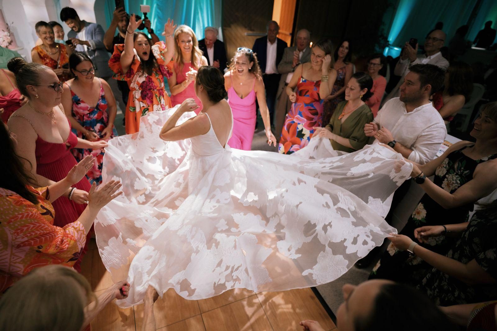 Frannie and Dustin dance the Hora in their wedding attire surrounded by guests at the Curaçao Marriott Beach Resort