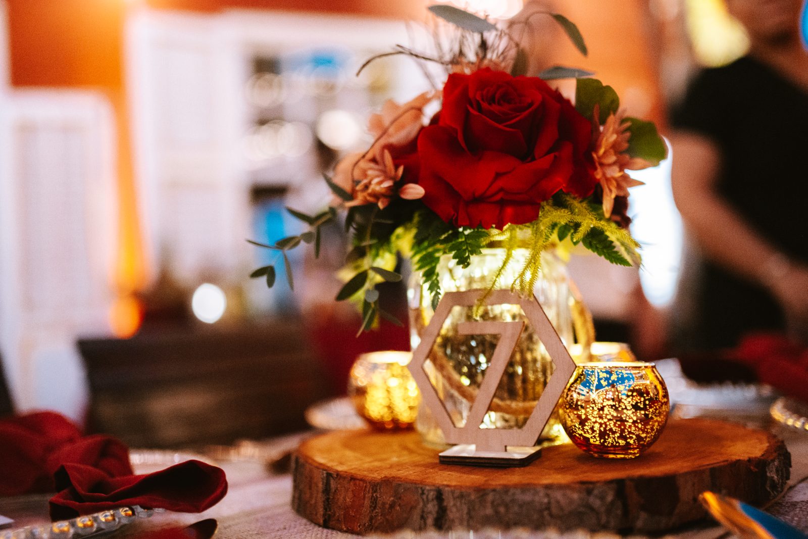 Gaëlle and Jeroen sit at a beautifully decorated table with flowers and candles during their wedding reception at Avila Beach Hotel, Curaçao