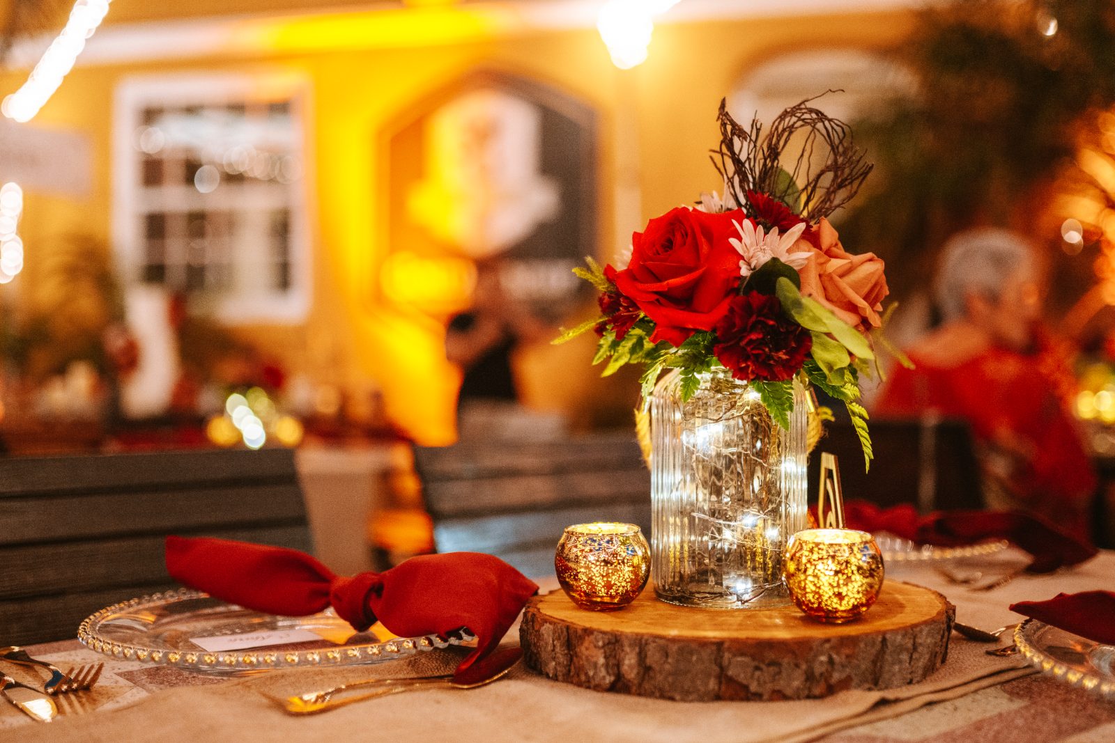 The wedding reception features a decorated table with a floral centerpiece and candles, set at Avila Beach Hotel in Curaçao