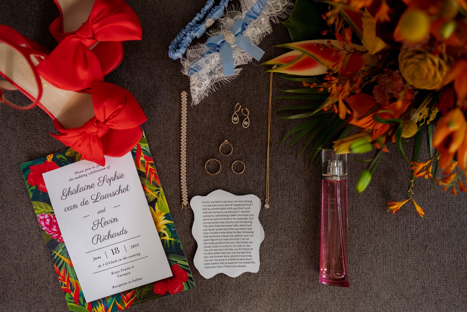 A wedding invitation, shoes, jewelry, and a bouquet are arranged on a table in a private garden in Curaçao