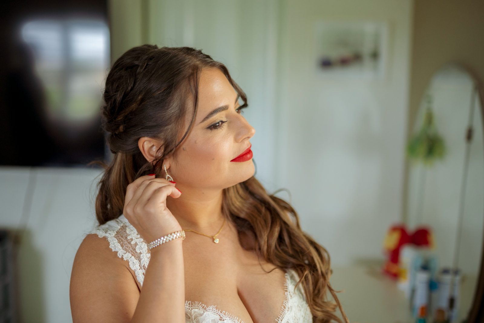 Ghislaine is adjusting her earring while preparing in a private garden in Curaçao for her wedding to Kevin