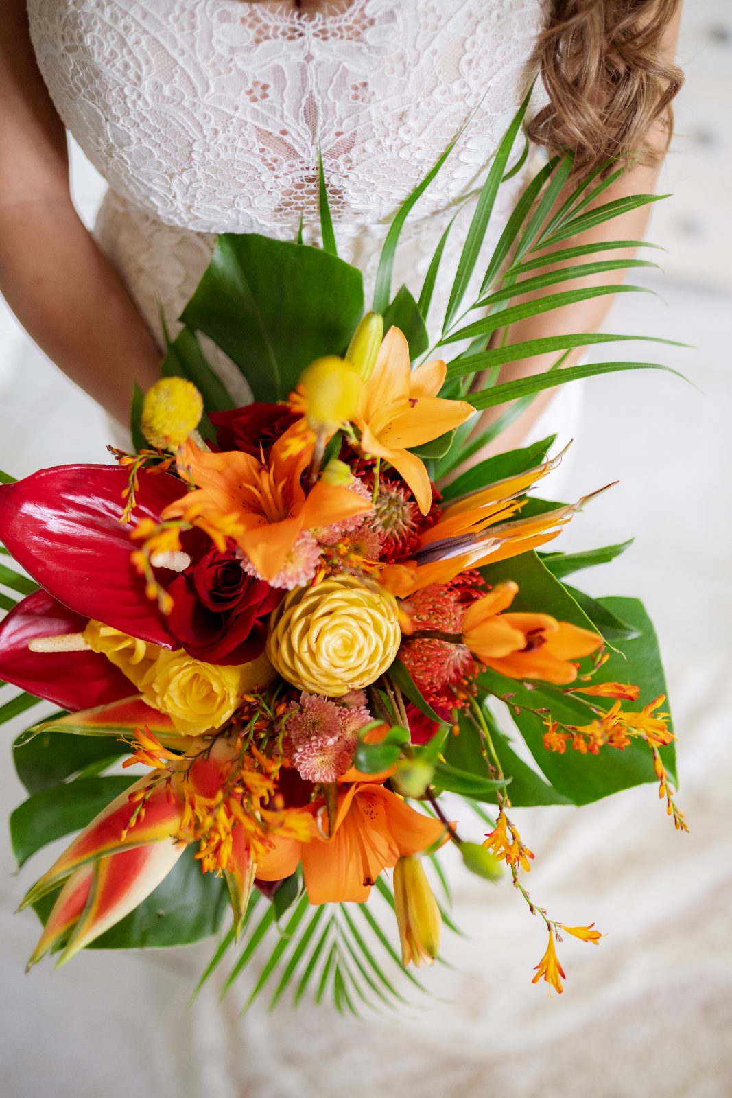 Ghislaine is holding a colorful bouquet of flowers in a private garden in Curaçao during her wedding to Kevin