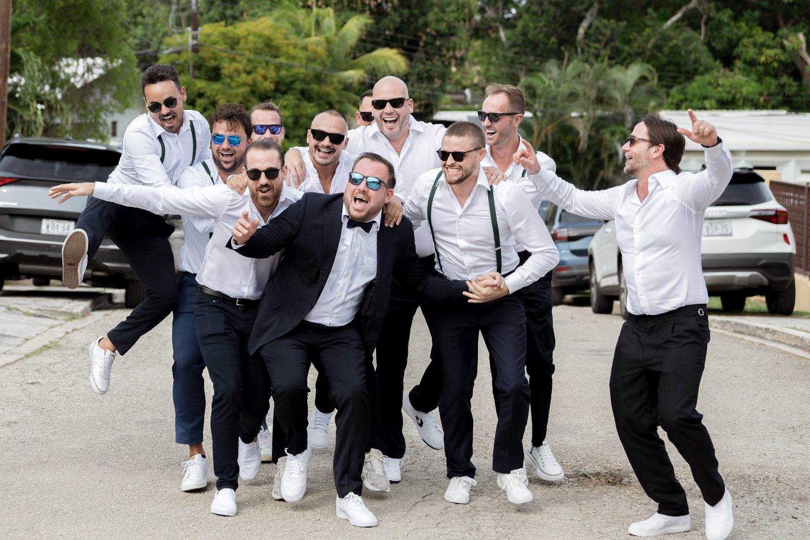 Ghislaine and Kevin's wedding features the groom and groomsmen celebrating joyfully in a private garden in Curaçao
