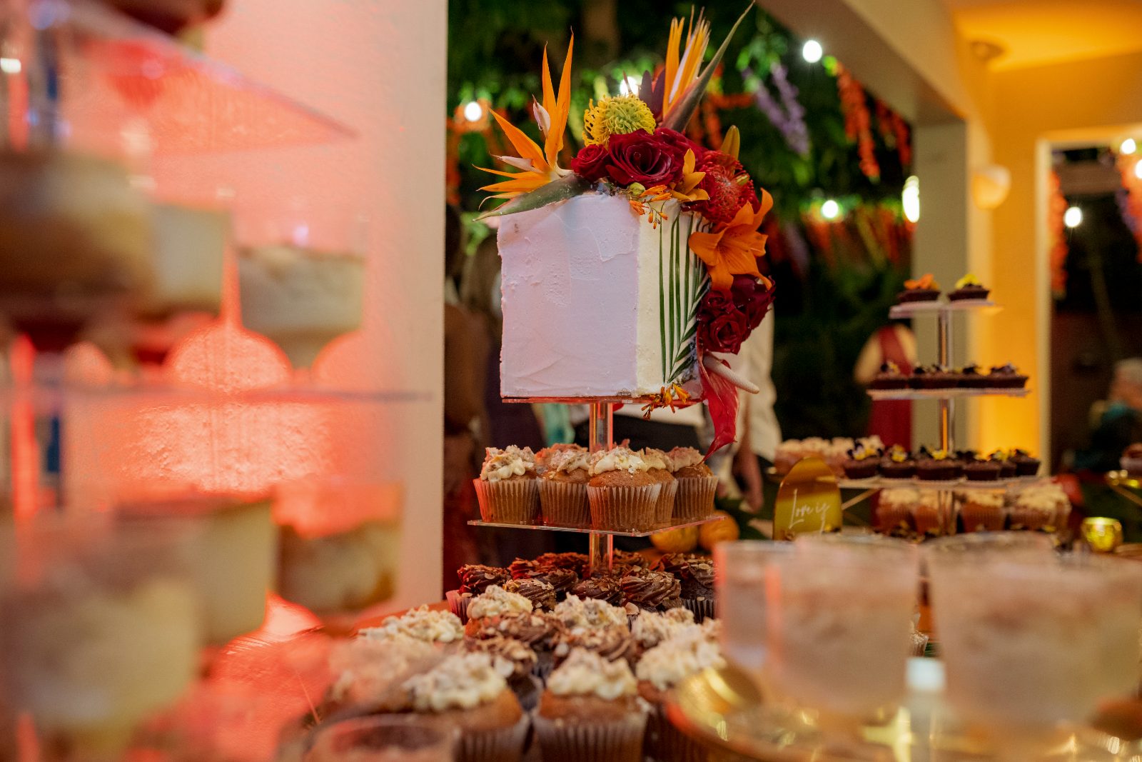 Ghislaine and Kevin's wedding features a dessert display with cakes, cupcakes, and drinks set in a private garden in Curaçao