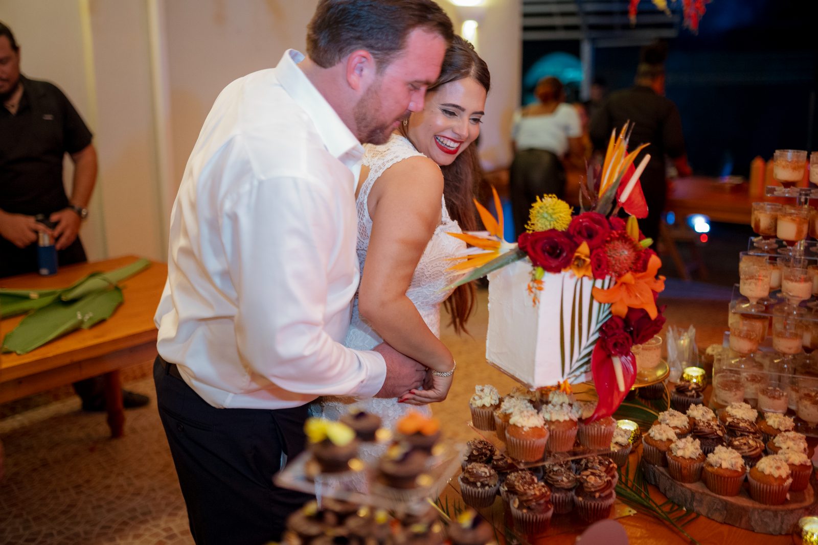 Ghislaine and Kevin smile together at their wedding reception in a private garden in Curaçao, surrounded by dessert displays