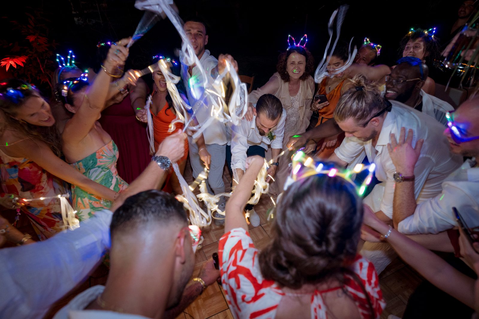 Ghislaine and Kevin celebrate their wedding in a private garden in Curaçao, surrounded by dancing guests wearing light-up accessories