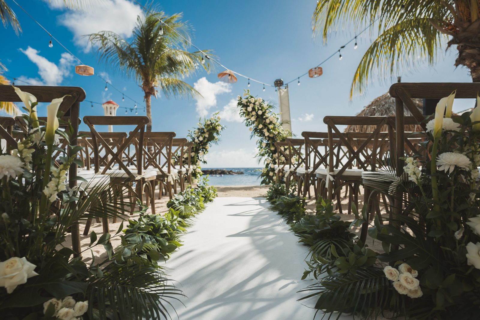 Jessica and Bogdan are getting married at Avila Beach Hotel in Curaçao, surrounded by chairs, floral decorations, and a view of the ocean