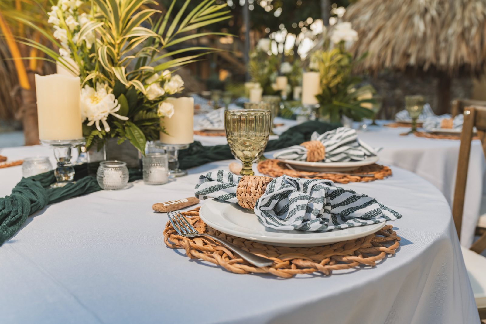 Jessica and Bogdan's wedding reception at Avila Beach Hotel in Curaçao features elegantly set tables with decorations and floral arrangements