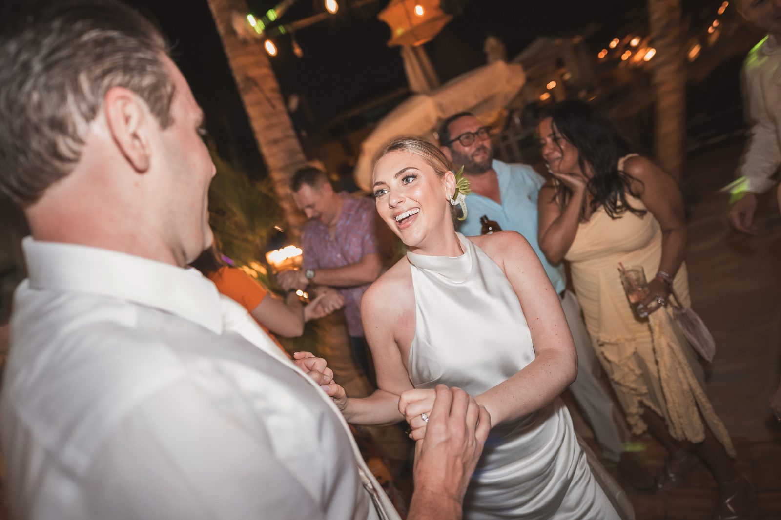 Jessica and Bogdan dance at their wedding reception with guests around them at the Avila Beach Hotel in Curaçao