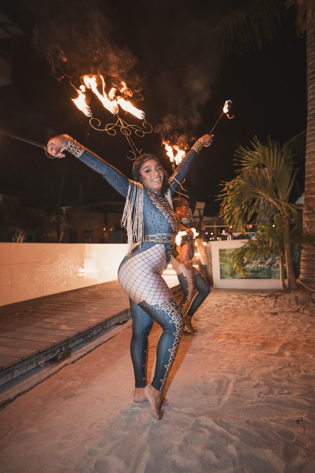 Jessica and Bogdan's wedding at Avila Beach Hotel features a dancer performing with fire in the sand at night