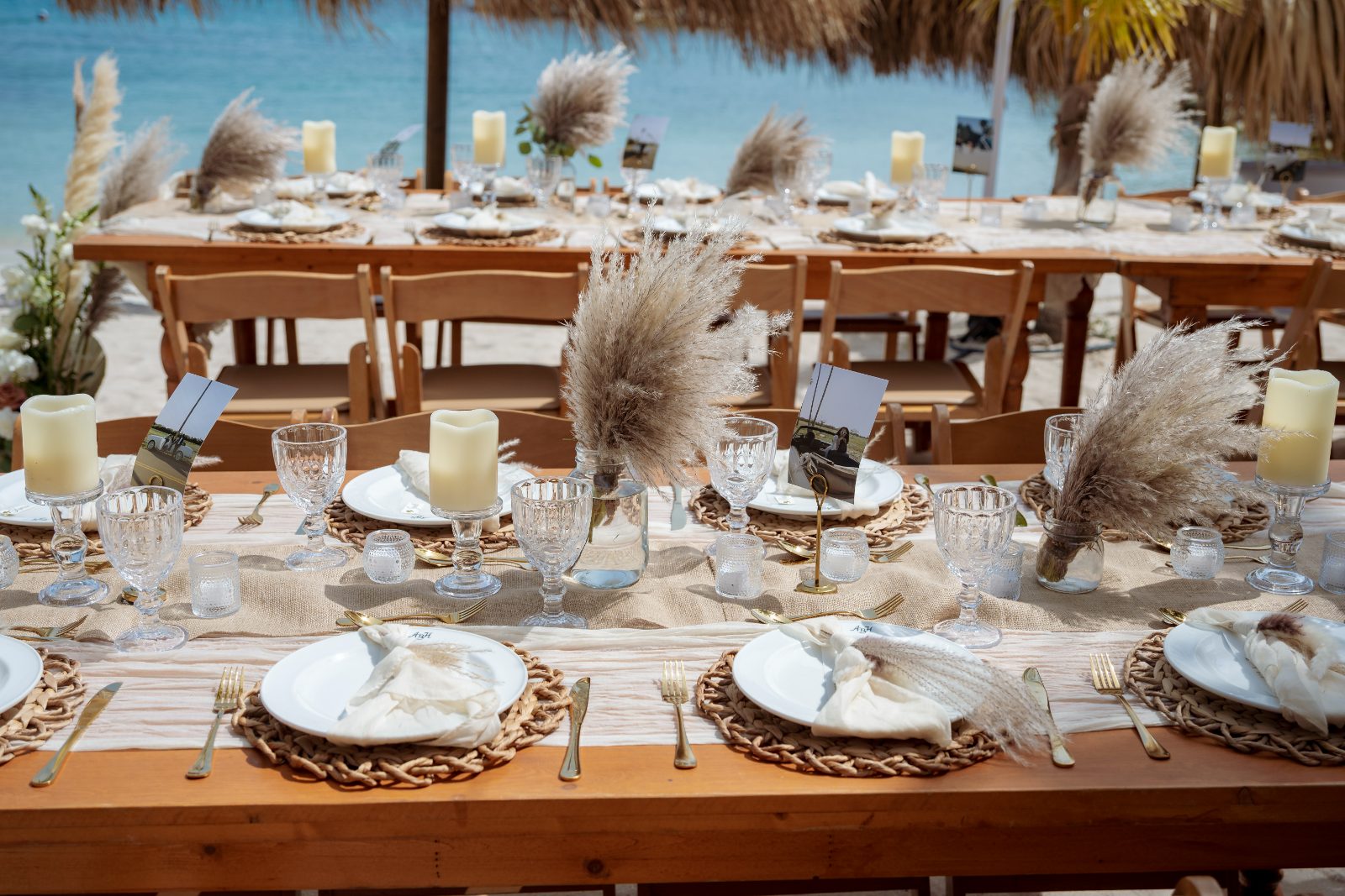 Kayla and Anthony's wedding reception at Avila Beach Hotel features elegantly set tables with candles and decorative arrangements by the beachfront