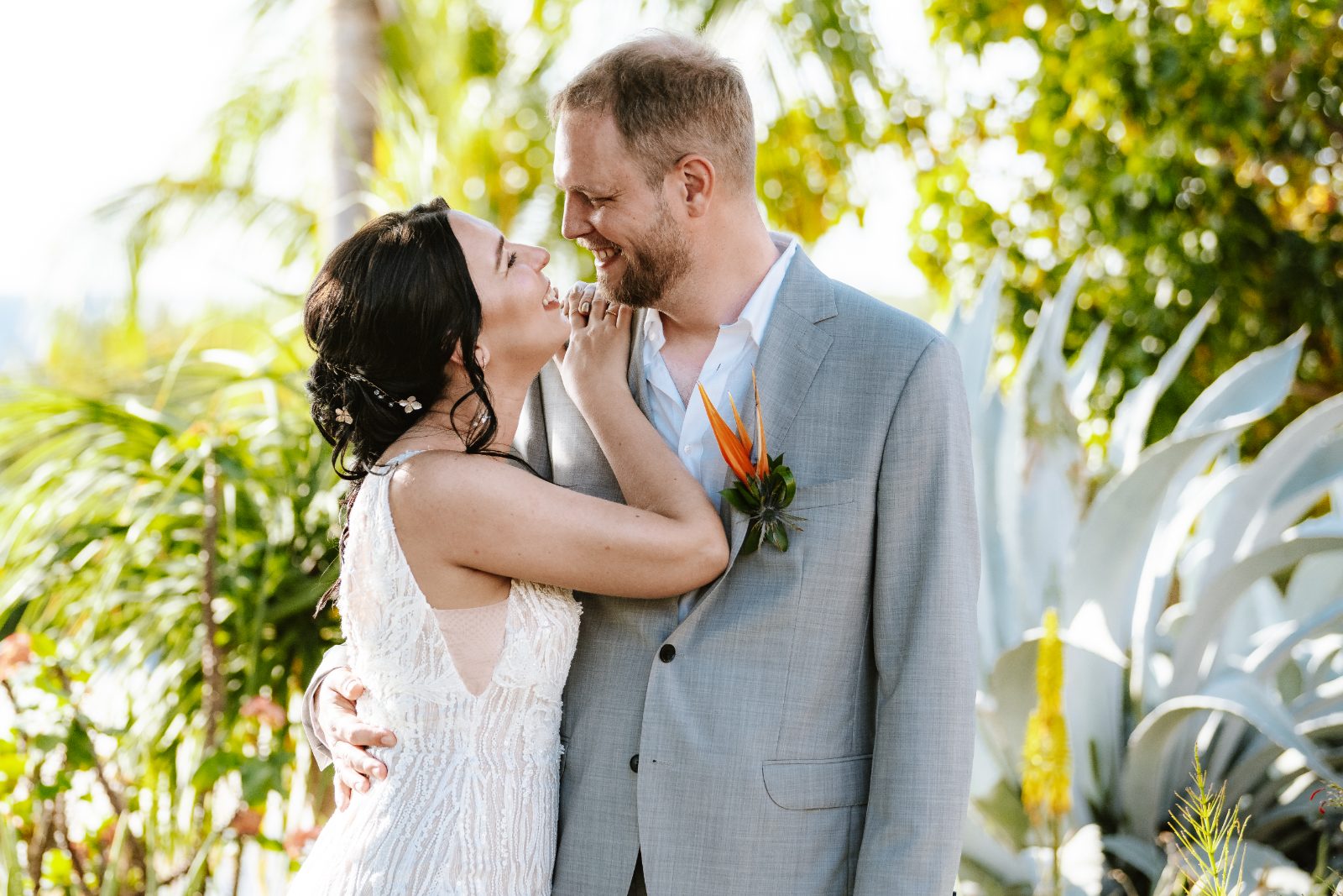 Kinga and Sven embrace and smile at each other during their first look at Karakter in Curaçao, surrounded by tropical plants