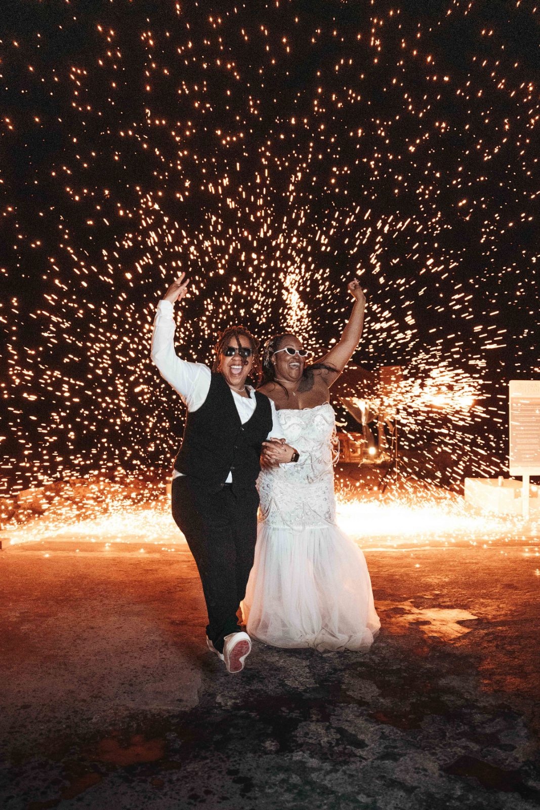 Kristal and Brittany celebrate their wedding at Karakter, Curaçao, surrounded by sparklers in a lively moment of joy
