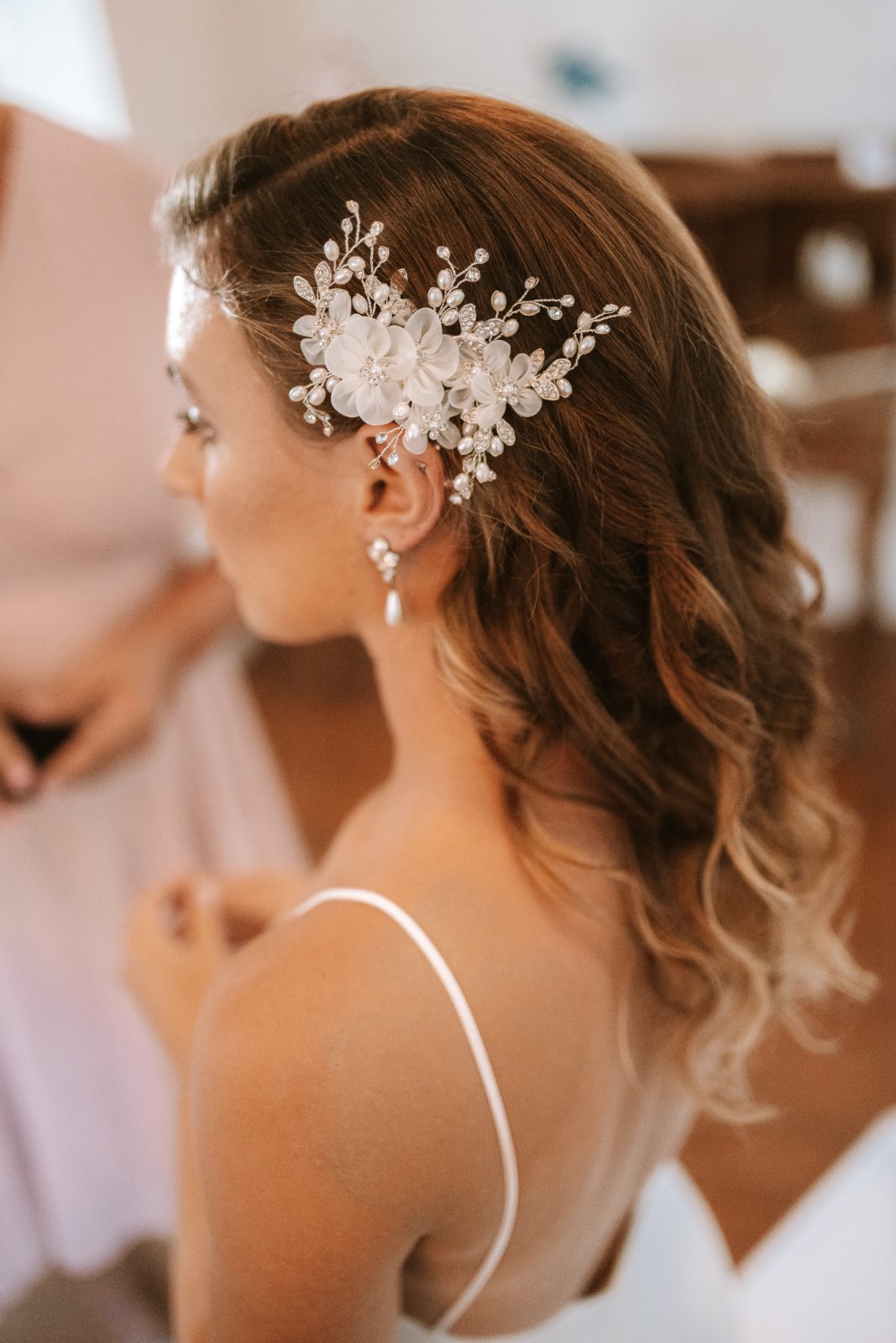 Megan stands with her back to the camera, wearing a wedding dress and hair embellishment, in a venue in Curaçao