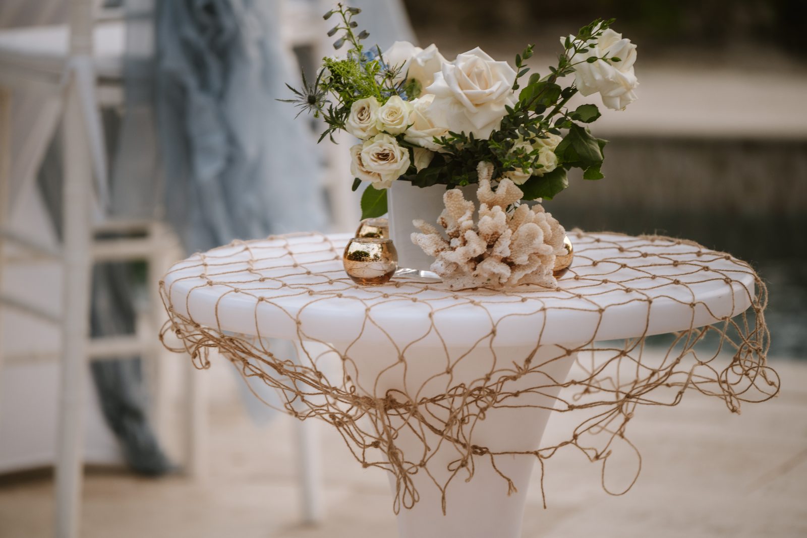 Megan and Nathan's wedding features a decorated table with flowers and coral, set in Curaçao near a pool area