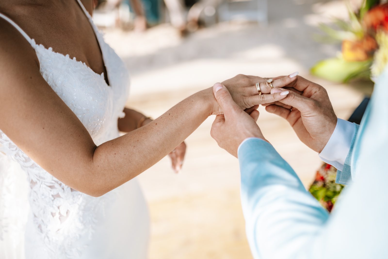 Sharon and Robin are exchanging rings during their wedding ceremony at MOOD Beach in Curaçao