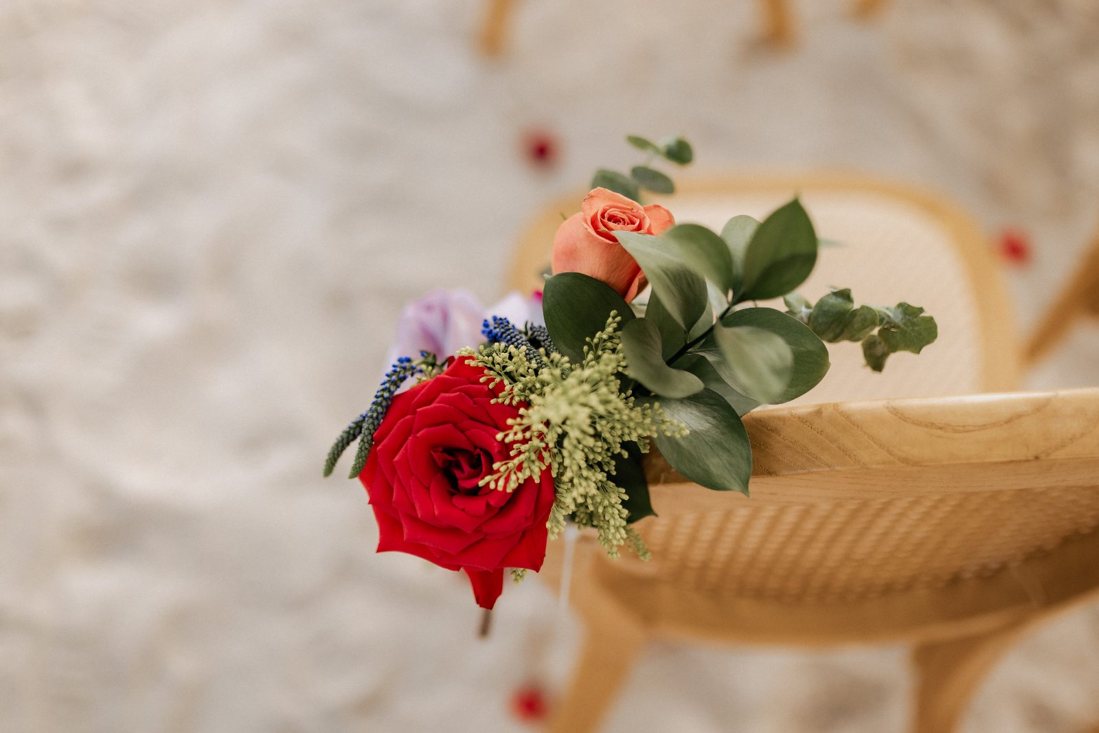 Stephanie and Simon's wedding at Avila Beach Hotel, Curaçao features a decorated chair with red and pink flowers